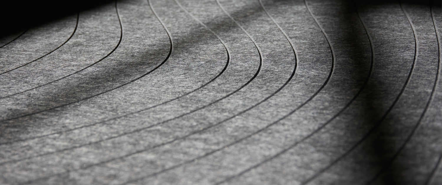 Lignes courbes et parallèles sur une surface grise texturée avec des motifs d'ombre et de lumière.